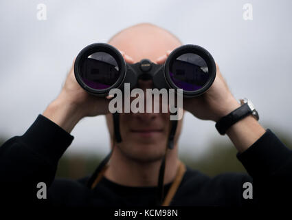 Young man looking througt binoculars Stock Photo