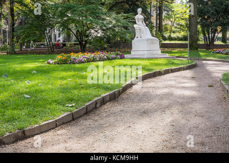 The monument to Sissi is hidden by greenery along the Promenade of Merano (Meran), next to the post bridge. South Tyrol, northern Italy Stock Photo