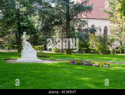 The monument to Sissi is hidden by greenery along the Promenade of Merano (Meran), next to the post bridge. South Tyrol, northern Italy Stock Photo