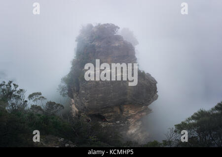 Foggy day in the blue mountains. Dramatic rock formations rising through the thick fog Stock Photo