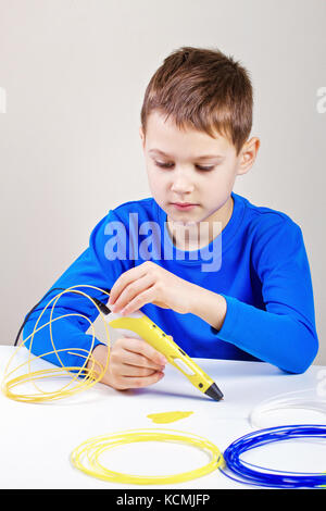 Boy using 3d printing drawing pen. Creative, leisure, technology education concept Stock Photo