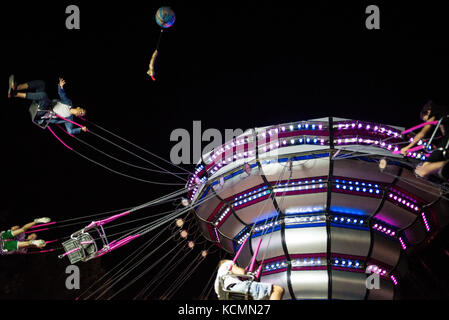 A funny ride in chairoplane with friends in an amusement Italian park at night Stock Photo