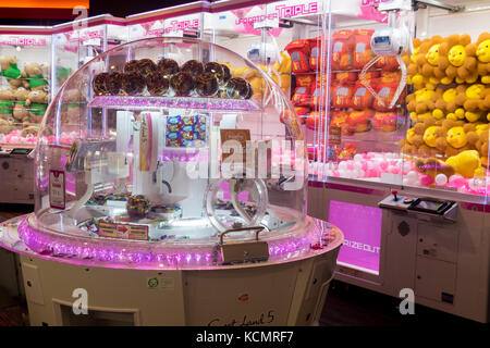 Gaming club with crane machines. Play room with automate for sweets. Stock Photo