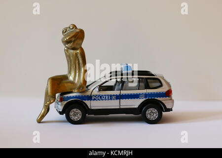 A frog in love sitting on top of a toy police car. Stock Photo