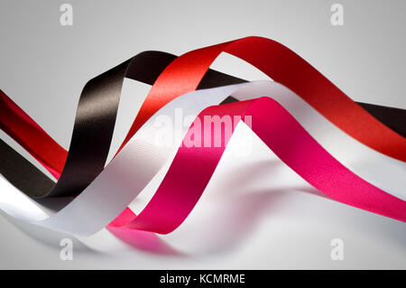 Four curled ribbons in pink, red, brown and white color Stock Photo