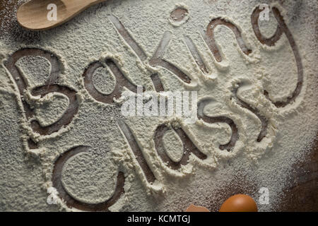 Close-up of the word baking class written on sprinkled flour Stock Photo