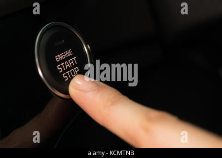 Cropped finger pressing start button in car while test driving Stock Photo