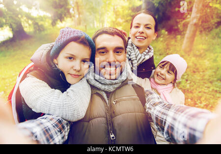 family with backpacks taking selfie and hiking Stock Photo