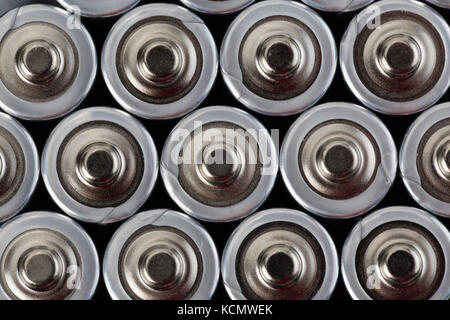 Close up top view on blurred rows of AA batteries energy abstract background of batteries. Shallow depth of field. Stock Photo