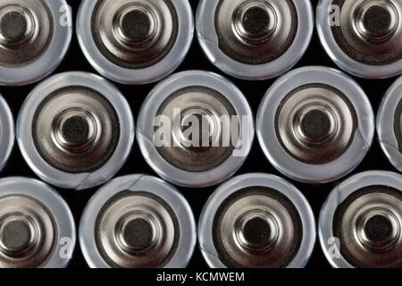 Close up top view on blurred rows of AA batteries energy abstract background of batteries. Shallow depth of field. Stock Photo