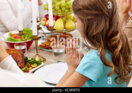 girl with family having dinner and praying at home Stock Photo