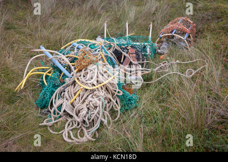 A pile of assorted ropes and fibrous cord and fishing pots await removal from the coastal landscape, having been collected by volunteers from a beach on Holy Island, on 27th September 2017, on Lindisfarne Island, Northumberland, England. The amount of rubbish found dumped on UK beaches rose by a third last year, according to a new report. More than 8,000 plastic bottles were collected by the Marine Conservation Society’s annual beach clean-up at seaside locations from Orkney to the Channel Islands on one weekend in September 2016. The Holy Island of Lindisfarne, also known simply as Holy Islan Stock Photo