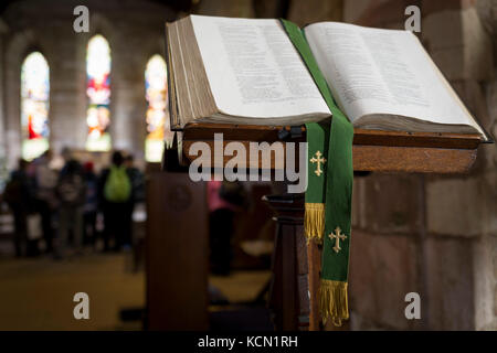 An open Christian Bible in the interior of St. Mary's church on Holy Island, on 27th September 2017, on Lindisfarne Island, Northumberland, England. The Holy Island of Lindisfarne, also known simply as Holy Island, is an island off the northeast coast of England. Holy Island has a recorded history from the 6th century AD; it was an important centre of Celtic and Anglo-saxon Christianity. After the Viking invasions and the Norman conquest of England, a priory was reestablished. Stock Photo
