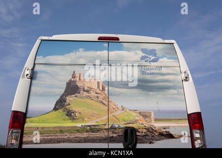 The rear of a National Trust membership van features Lindisfarne castle, on 27th September 2017, on Lindisfarne Island, Northumberland, England. The Holy Island of Lindisfarne, also known simply as Holy Island, is an island off the northeast coast of England. Holy Island has a recorded history from the 6th century AD; it was an important centre of Celtic and Anglo-saxon Christianity. After the Viking invasions and the Norman conquest of England, a priory was reestablished. Stock Photo