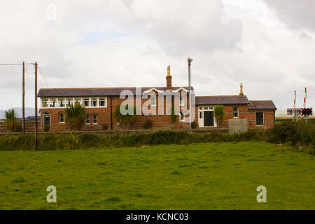 The refurbished automatic rail crossing and station house at Magilligan on the North coast of Ireland in County Londonderry on a dull day Stock Photo