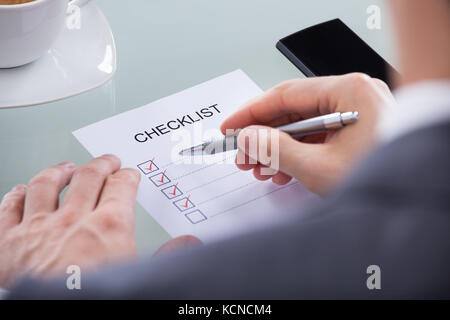 Hand with red pen marking a check box Stock Photo - Alamy