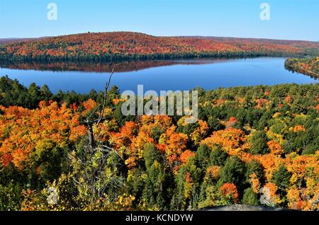 The breathtaking view of Rock Lake in Algonquin Park with calm water and reflections of colorful Autumn foliage from the lookout of Booth's Rock Trail Stock Photo