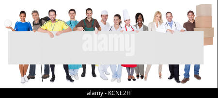 Group of diverse professionals presenting empty banner. Isolated on white Stock Photo