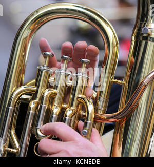 hand of boy plays the trombone in the brass band during sound performance Stock Photo