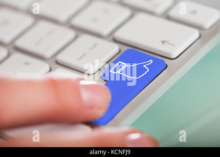 Close-up Of Finger On Enter Button With Like Icon On Computer Keyboard Stock Photo