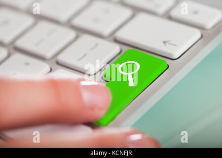 Close-up Of Hand Over Search Enter Button On Keyboard Stock Photo