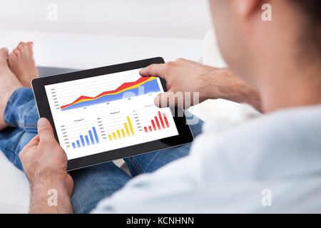 Close-up Man Analyzing Financial Statistics Displayed On The Tablet Screen Stock Photo