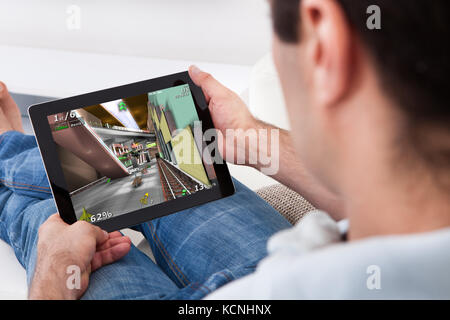 Close-up Of Young Man Playing Video Game On Tablet Pc Stock Photo