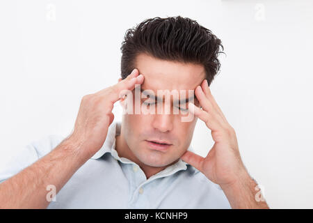 Young Man Having Headache Over White Background Stock Photo