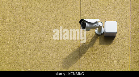 Infrared cctv camera on the exterior textured wall in yellow color with light and shadow, selective focus. Stock Photo