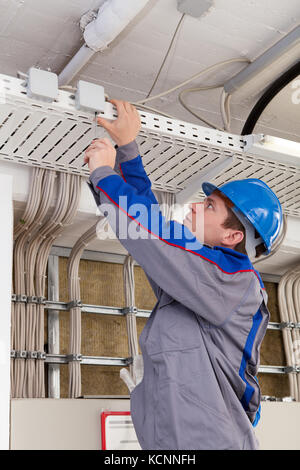Portrait of male worker working in office wearing hard hat Stock Photo