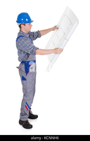 Male construction worker looking at blue prints isolated on white background Stock Photo