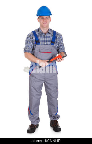 Smiling handsome handyman in work with tool isolated on white background Stock Photo
