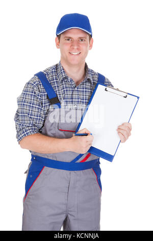 Young construction worker writing on clipboard isolated on white background Stock Photo