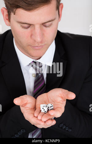 Close up of businessman in suit holding dice Stock Photo