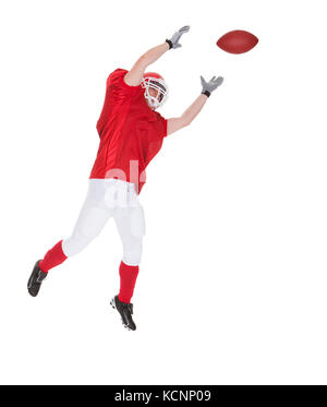 Portrait Of American Football Player Catching A Ball Over White Background Stock Photo