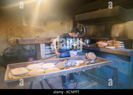 Imilchil, Morocco - Jan 10, 2017: Worker in traditional bread bakery. Morocco Stock Photo