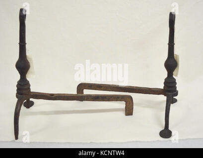 This image shows a hand-wrought metal andiron set, crafted with attention to detail. Andirons are a traditional fireplace accessory used for holding logs in place and promoting airflow. Stock Photo