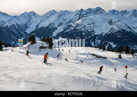 ZILLERTAL ARENA, AUSTRIA - JANUARY 04, 2011 - Group of skiers skiing down the mountain ski slopes Stock Photo