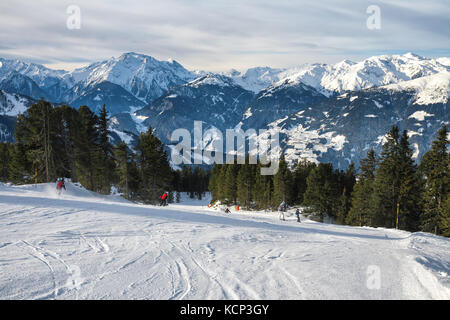 Group of skiers skiing down the mountain ski slopes at sunny day Stock Photo