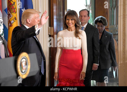 United States President Donald J. Trump waves to the attendees as he and first lady Melania Trump arrive at a Hispanic Heritage Month event in the East Room of the White House in Washington, DC on Friday, October 6, 2017. 200 Hispanic business, community, and faith leaders, and guests from across the country have been invited to join in the celebration. Walking behind the first lady are US Secretary Of Labor Alex Acosta and US Treasurer Jovita Carranza. Credit: Ron Sachs/CNP/MediaPunch Stock Photo