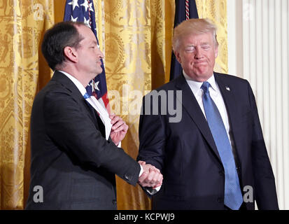 United States President Donald J. Trump shakes hands with US Secretary of Labor Alex Acosta at a Hispanic Heritage Month event in the East Room of the White House in Washington, DC on Friday, October 6, 2017. 200 Hispanic business, community, and faith leaders, and guests from across the country have been invited to join in the celebration. Credit: Ron Sachs/CNP/MediaPunch Stock Photo