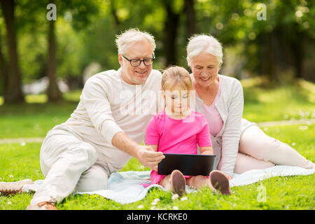 grandparents and granddaughter with tablet pc Stock Photo