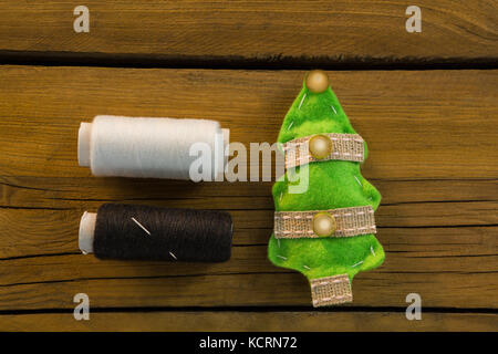 Overhead view of thread spools by Christmas decoration on table Stock Photo
