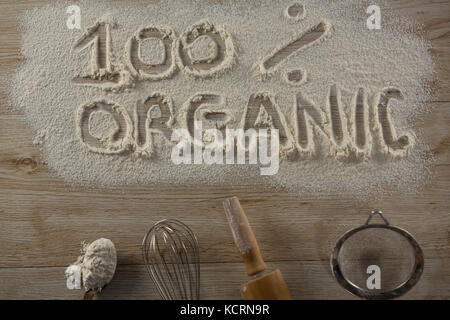 Over head view of the word 100 percent organic written on sprinkled flour Stock Photo