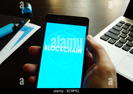 Man holding smart phone  with Blockchain. Stock Photo