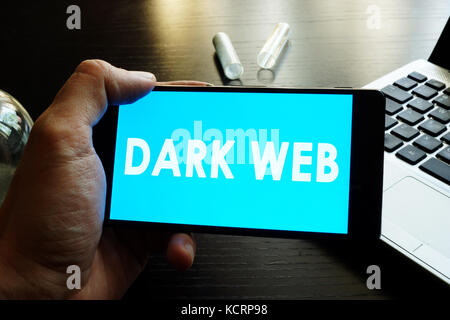 Man holding smart phone  with Dark Web. Stock Photo