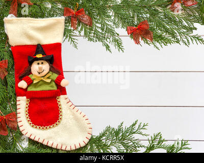 Stocking Befana and Christmas decorations on wooden white background Stock Photo