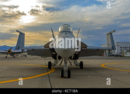 In this shot a U.S. Navy E/F-18E Super Hornet sits on the tarmac at sunset at the Historic Wendover Airfield in Wendover, Utah, USA. Stock Photo