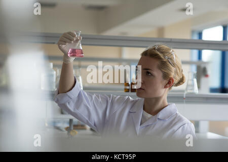 Attentive university student doing a chemical experiment in laboratory Stock Photo