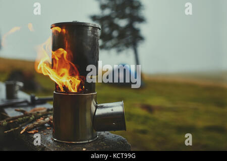 Cooking in a pot over the firewood stove. Foggy rainy weather on background Stock Photo